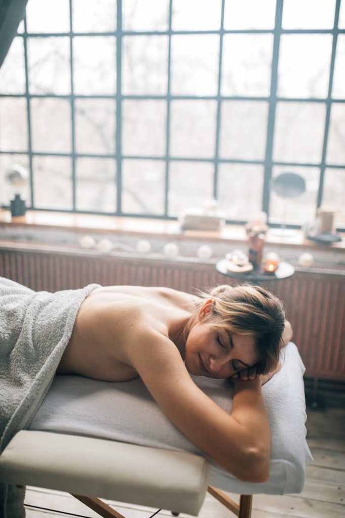 Woman enjoys a relaxing massage on a massage table in a soothing spa setting.